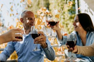 BuyWinesOnline.com Review: Best for Self-Select Shoppers? A cheerful group enjoying red wine outdoors in a festive celebration.