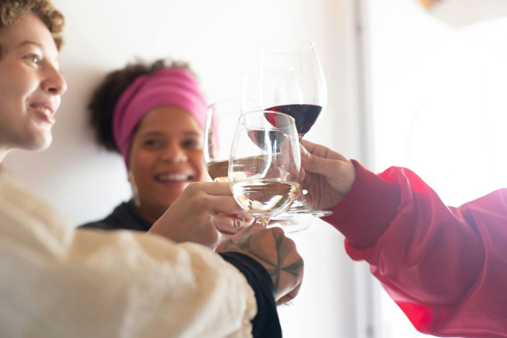 Group of friends joyously toasting with wine glasses, capturing a lively celebration mood.