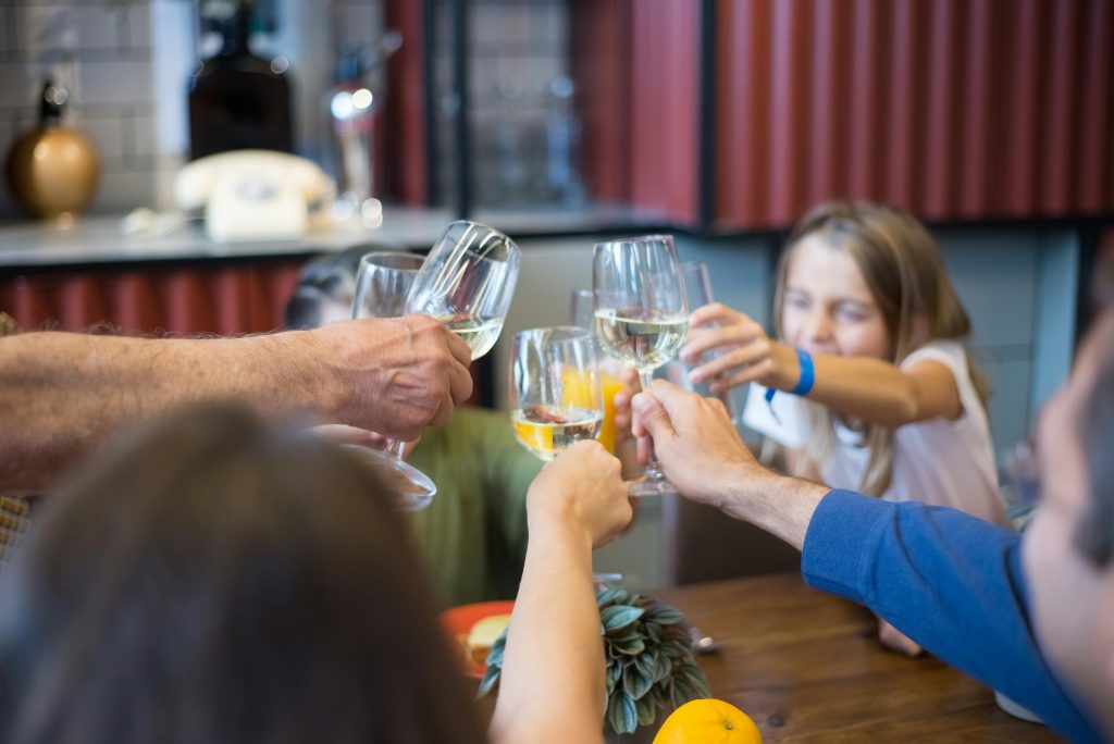 A group of people toasting with wine glasses, celebrating indoors in Portugal.
