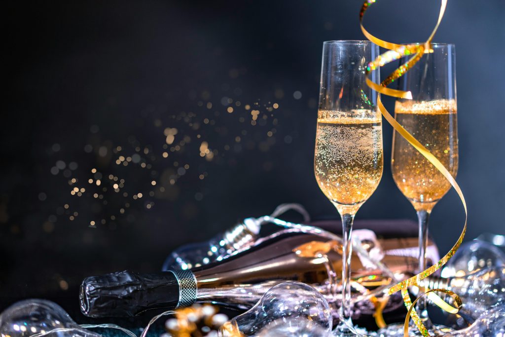 Two champagne glasses with a bottle and festive decorations, perfect for celebrations.