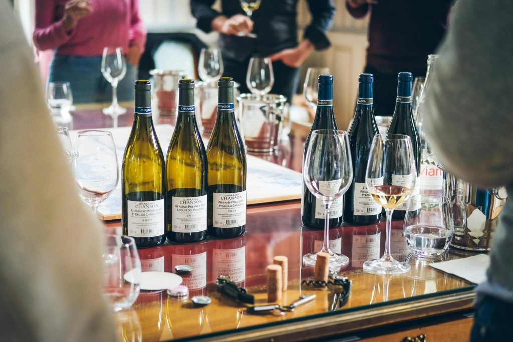 6 Wine Tasting Mistakes You're Probably Making A vibrant wine tasting event showcasing bottles and glasses on a table in Beaune, France.
