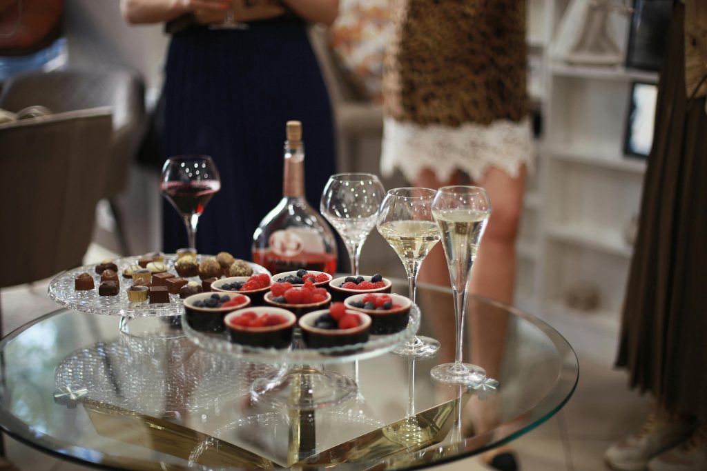7 Tasty Pairings For Dessert and Wine Elegant glass table setup with desserts and wine, featuring berries and chocolate treats, perfect for social gatherings.