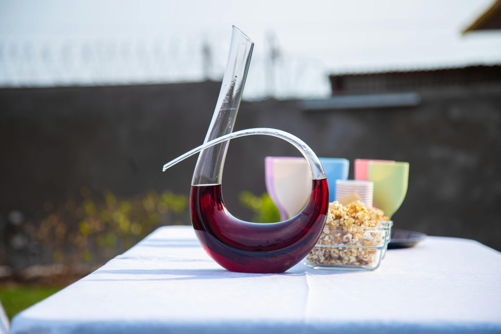 Sophisticated outdoor setup featuring a modern wine decanter with popcorn and glasses.