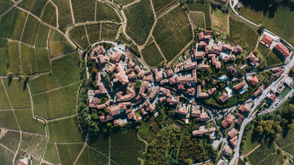 Stunning aerial shot of Castiglione Falletto, Italy, showcasing vineyards and rustic architecture.