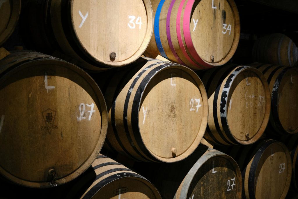 Close-up of stacked wooden wine barrels in a Brussels wine cellar, showcasing wine production and storage.
