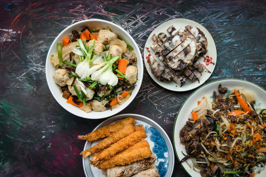An appetizing top view of a Vietnamese feast featuring assorted meat, vegetables, and noodles.