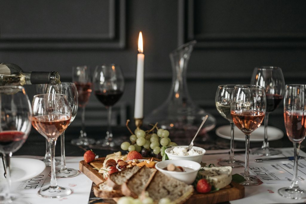 Sophisticated indoor wine tasting setup with cheese, fruits, and candlelight for a cozy atmosphere.