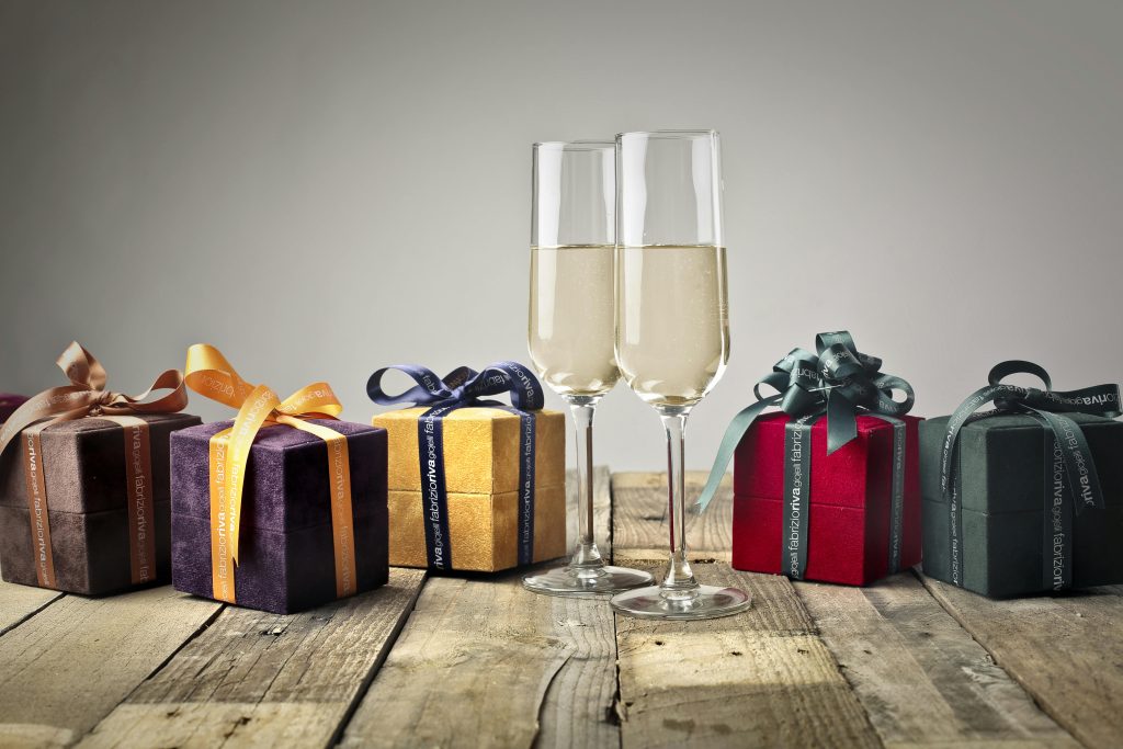 Best Wine Gifts for Father's Day (USA&UK) Luxurious gifts with ribbons and champagne flutes on a wooden table, perfect for celebrations.