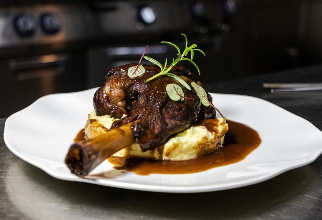 Wine and Lamb Pairing: The Definitive Guide Delicious roasted lamb shanks served on creamy mashed potatoes with rich gravy.