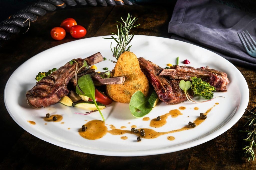 Wine and Lamb Pairing: The Definitive Guide Delight in a gourmet lamb chop meal with vibrant vegetables and herbs on a elegant plate.