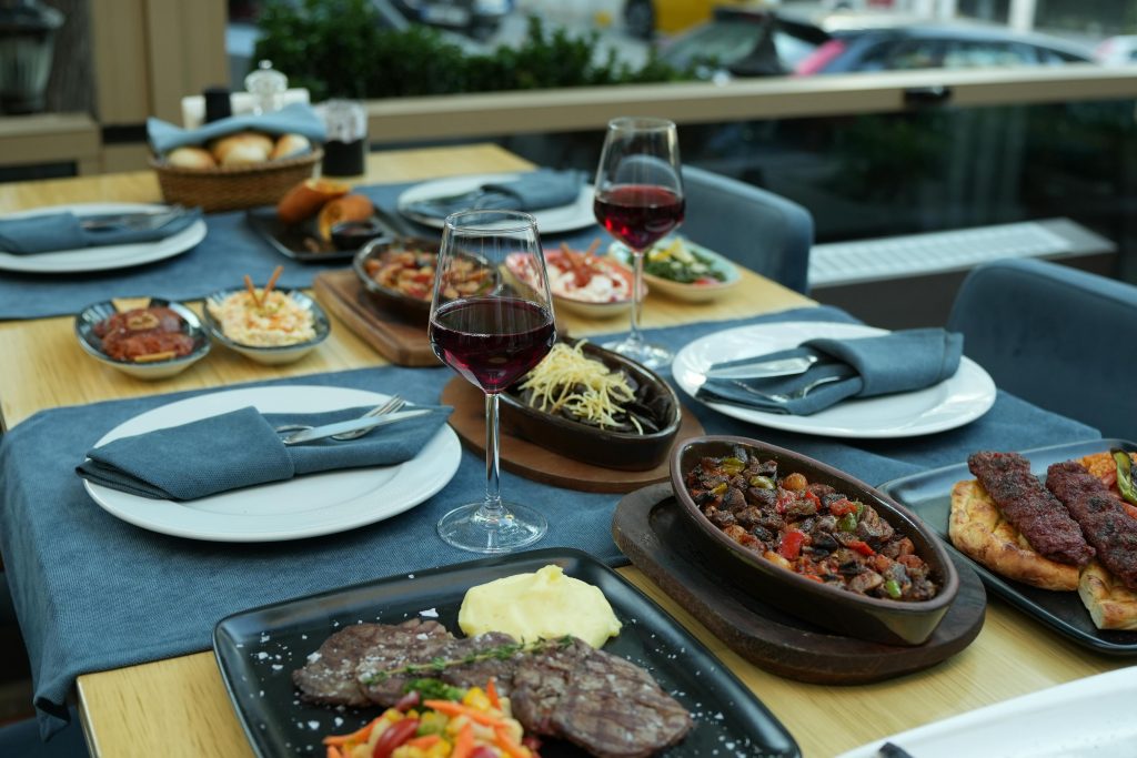 Wine and Steak Pairing: Best Bottles for Every Cut A beautifully set table in a restaurant with various dishes and glasses of red wine, perfect for fine dining.