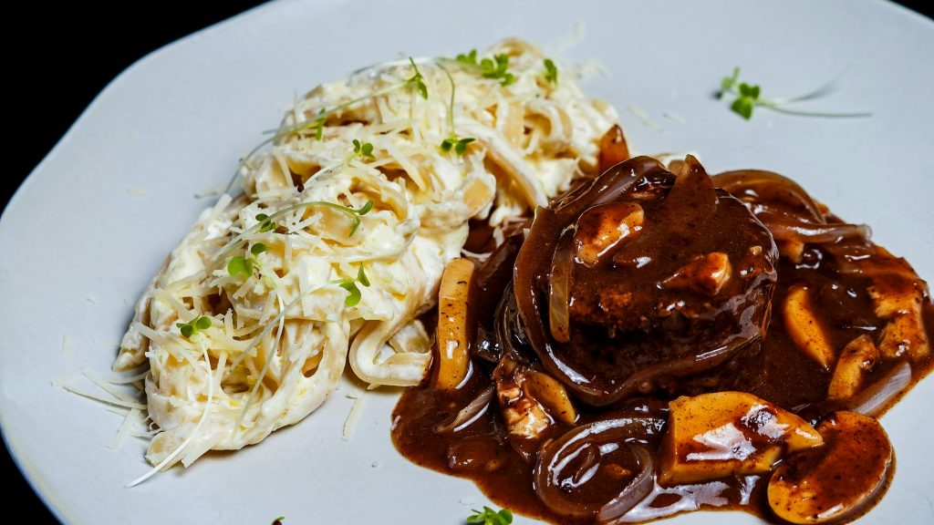 Wine and Steak Pairing: Best Bottles for Every Cut Delicious plate of creamy fettuccine alfredo paired with tender beef steak and rich mushroom sauce.