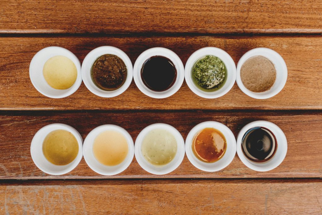 Wine and Lamb Pairing: The Definitive Guide Assorted sauces displayed in bowls on a rustic wooden table.