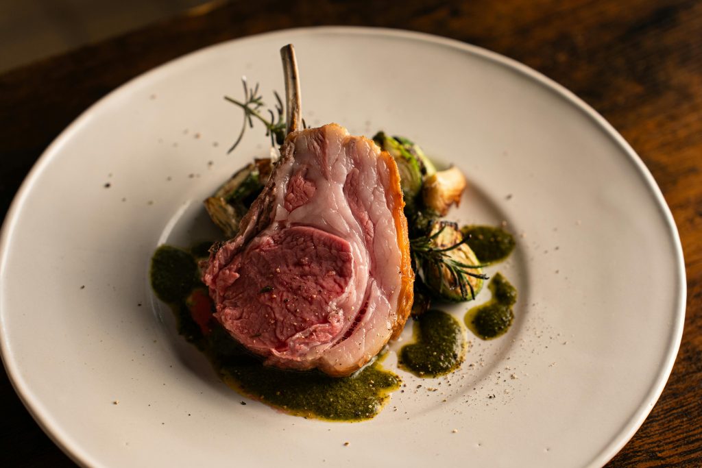 Wine and Lamb Pairing: The Definitive Guide Delicious gourmet lamb chop served with herb sauce in a fine dining setting, Tokyo.