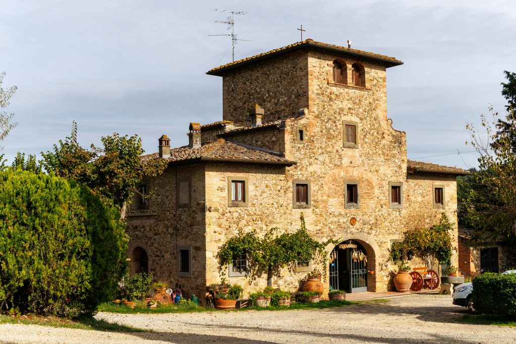 Charming rustic stone farmhouse surrounded by greenery, located in the Italian countryside.
