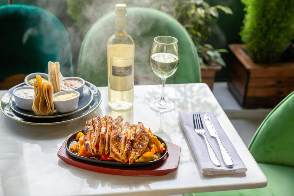 Tempting grilled chicken served with white wine on a sunlit table, perfect for a culinary delight.