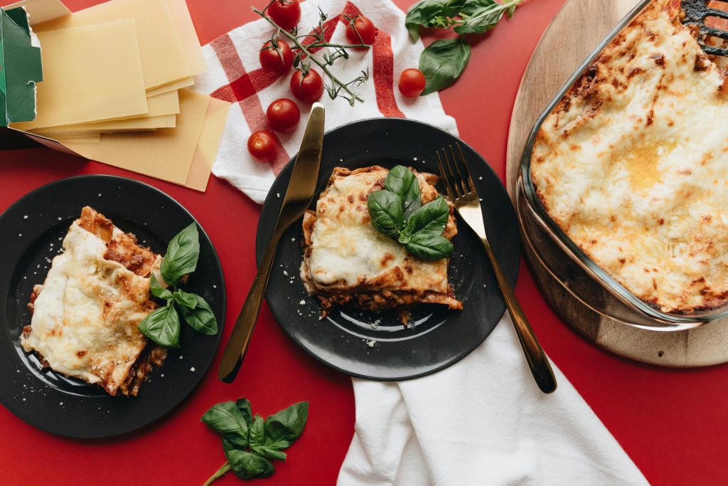 Delicious homemade lasagna with fresh basil and cherry tomatoes, perfect for food lovers.
