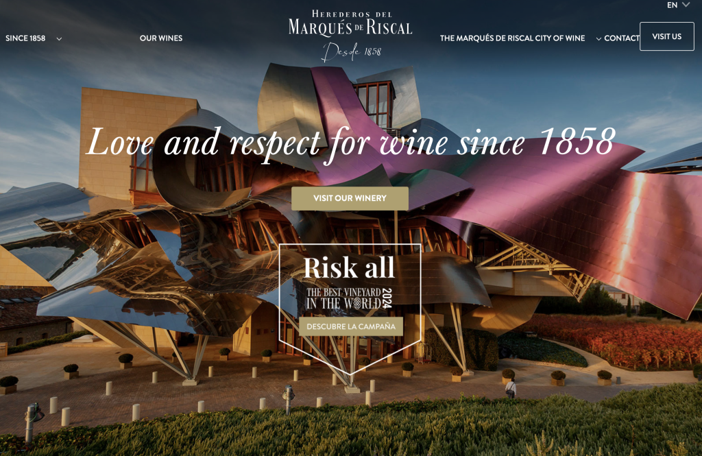 striking modern winery building with metallic, curved surfaces and vibrant colors; text overlay reads “love and respect for rioja wine since 1858” with buttons for visiting the winery and discovering a wine campaign.