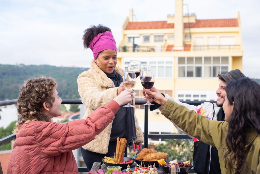 A cheerful group of friends enjoying a rooftop wine toast in Portugal.