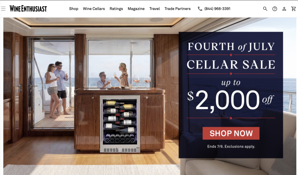 a luxurious yacht interior with a wine fridge and four people enjoying drinks; a large banner advertises a fourth of july cellar sale for up to $2,000 off at wine enthusiast—one of the top wine websites and wineanorak.com alternatives in 2026.