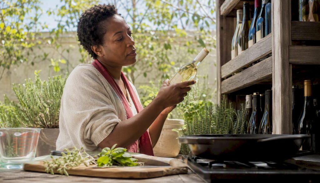 Woman choosing affordable white cooking wine bottle